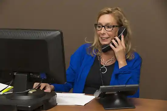 woman talking on phone looking at computer