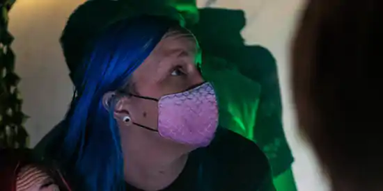  blue haired woman with pink face mask