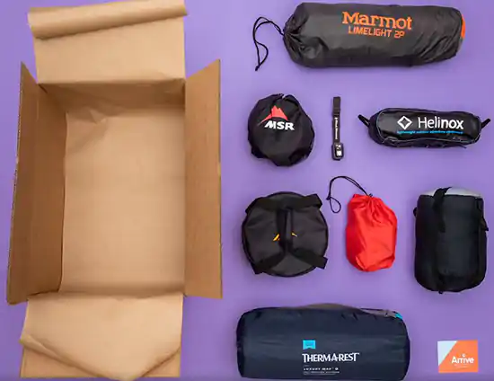 unpacked box with camping gear on blue background