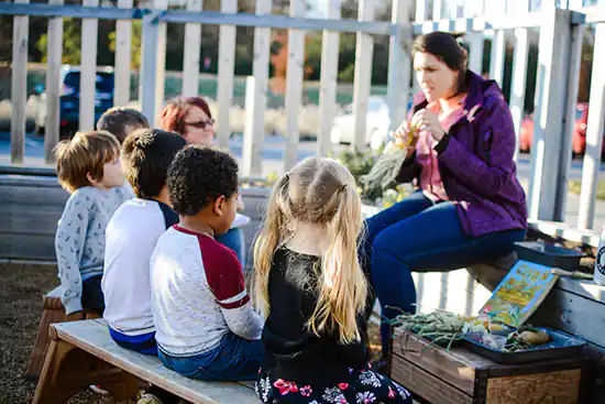 Teacher talking to kids in the garden