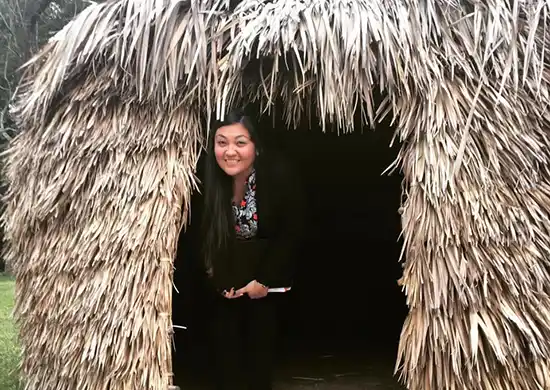 young woman in primitive house made from dry corn 
